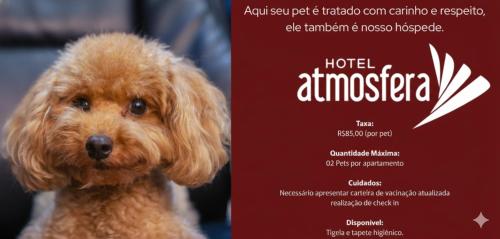 a dog is standing next to a sign at Hotel Atmosfera Feira de Santana in Feira de Santana