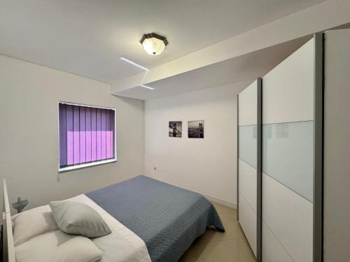 sypialnia z łóżkiem i oknem w obiekcie Apartments Amfora w Biogradzie na Moru