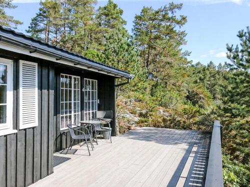 a deck with a table and chairs on a house at Holiday Home Evabu by Interhome in Øyuvstad