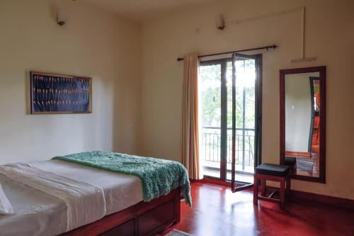 a bedroom with a bed and a sliding glass door at House StoneHaven in Kaniyāmbetta