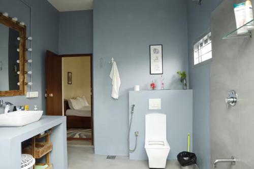 a bathroom with a white toilet and a sink at House StoneHaven in Kaniyāmbetta