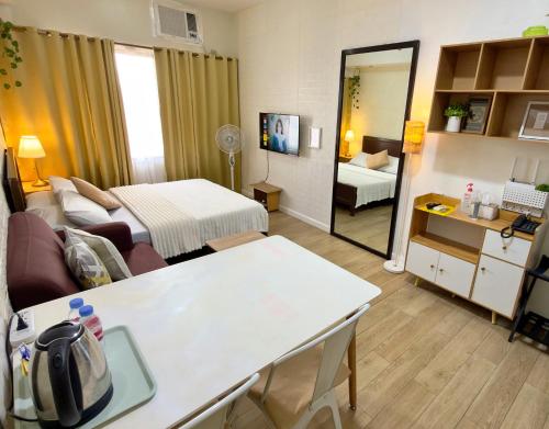 a room with a living room with a bed and a mirror at Hannah’s Morning Sun - Studio Room in Manila