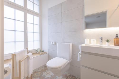 a white bathroom with a toilet and a sink at Bed and Breakfast Kloster Frienisberg in Seedorf