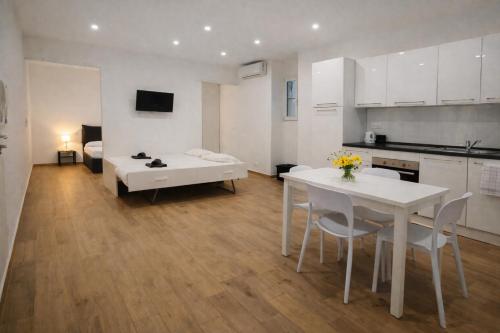 a kitchen and living room with a table and a couch at Maison TRENCA - fully equiped apartment in Menton