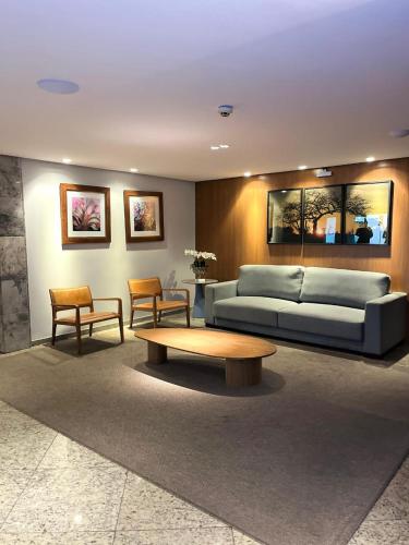a living room with a couch and a coffee table at Hotel Atmosfera Feira de Santana in Feira de Santana