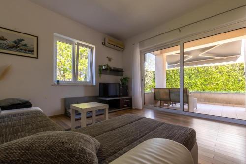 a living room with a couch and a tv at Apartment Vidak in Vantačići
