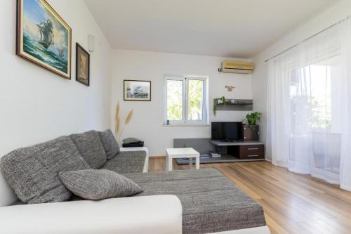 a living room with a couch and a tv at Apartment Vidak in Vantačići