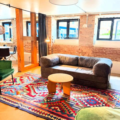 a living room with a couch and a table on a rug at Charming basement city apartment in Odense