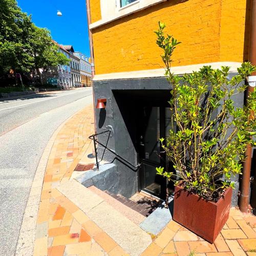a yellow building with a tunnel next to a street at Charming basement city apartment in Odense