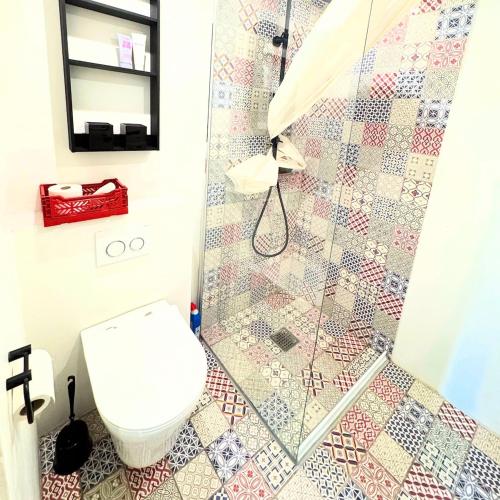 a bathroom with a toilet and a shower at Charming basement city apartment in Odense