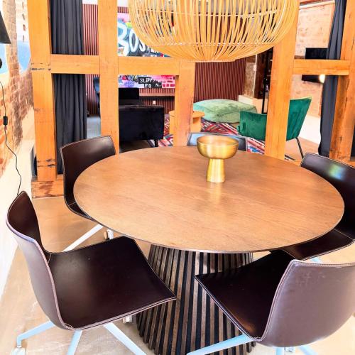 a wooden table and chairs in a room at Charming basement city apartment in Odense