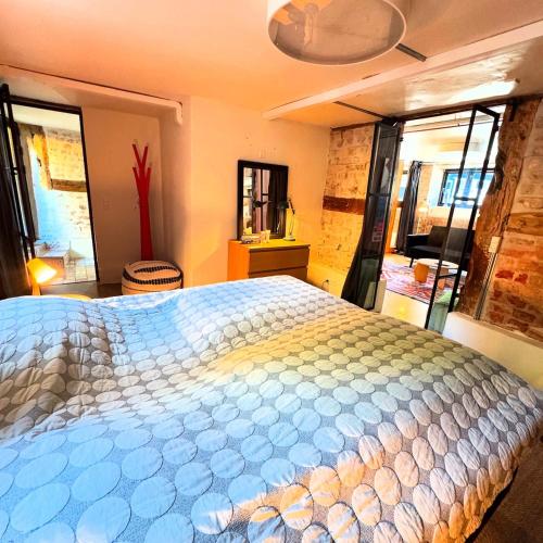 a bedroom with a large bed in a room with windows at Charming basement city apartment in Odense