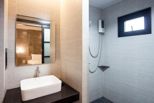 a bathroom with a sink and a mirror at Ritsurin Boutique Hotel - โรงแรมริทสุริน บูติค in Phuket