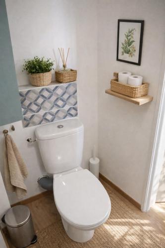 a bathroom with a toilet with two baskets on the wall at Studio neuf équipé, confortable et au calme in Issoire