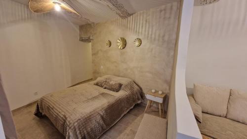 a small bedroom with a bed and a couch at Cocon de Nuit - appartement RDC, avec terrasse in Orange