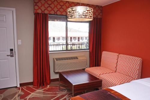 a bedroom with a bed and a chair and a window at Gateway Inn and Suites in Salida