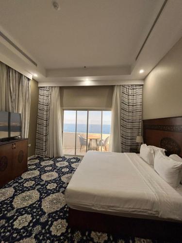 a hotel room with a bed and a view of the ocean at Vista Hotel Haql in Al Humaizah