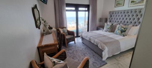 a bedroom with a bed and a view of the ocean at Dolphin Wave in Mossel Bay
