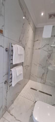a bathroom with a shower and a toilet and towels at Dolphin Wave in Mossel Bay