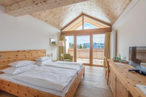a bedroom with a large bed and a large window at Hotel garni Kranzbichlhof in Dürrnberg