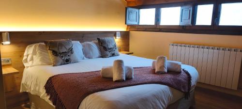a bedroom with a large white bed with two towels on it at Hotel Saurat in Espot