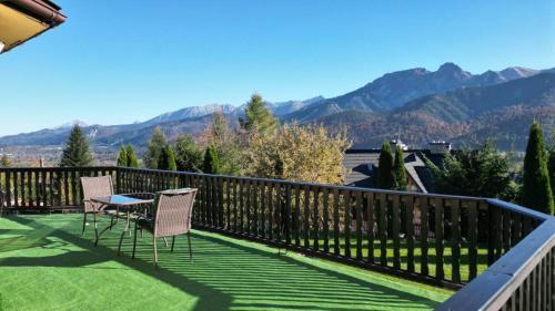 a balcony with chairs and a table and mountains at Apartamenty Butorówka Dream 100m2 , Kościelisko - Zakopane in Kościelisko