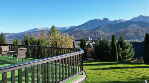 a balcony with a table and chairs and mountains at Apartamenty Butorówka Dream 100m2 , Kościelisko - Zakopane in Kościelisko