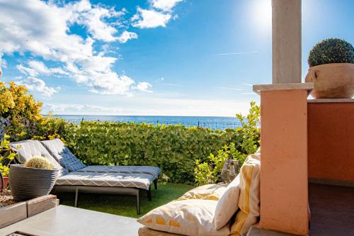 a patio with a couch and a view of the ocean at SEAHORSEROOM - Frontemare con Idromassaggio in Finale Ligure