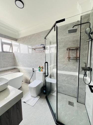 a bathroom with a toilet and a glass shower at Diamond Oark Residency in Gatunga