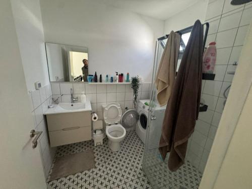 a bathroom with a toilet and a sink and a mirror at הבית של גיא בנאי in Beer Sheva