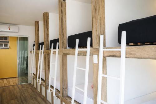 a row of white bunk beds in a room at Hostel House Santinho in Florianópolis