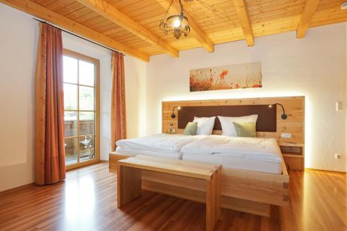 a bedroom with a large bed with a wooden headboard at Schauerhof in Chieming