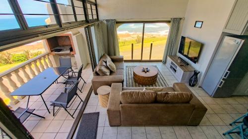 a living room with a couch and a table at Uvongo Cabanas 13B in Uvongo Beach
