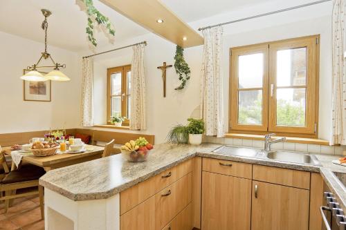 a kitchen with a sink and a dining room with a table at Schauerhof in Chieming
