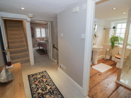 a hallway of a home with a bathroom and a sink at Bumblebee Cottage in Tetbury
