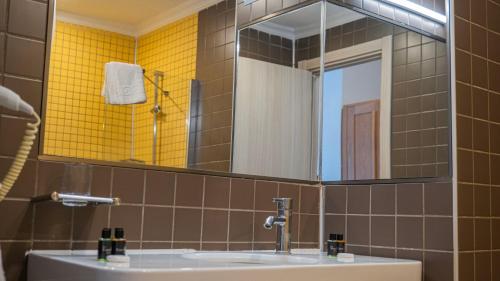 a bathroom with a sink and a mirror at Otel Kefalos in Gokceada Town