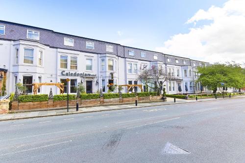 a row of white buildings on the side of a street at Caledonian Hotel in Newcastle upon Tyne