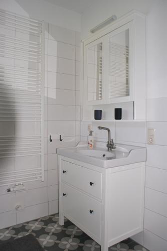 a white bathroom with a sink and a mirror at Ferienhaus Lilli in Pruchten