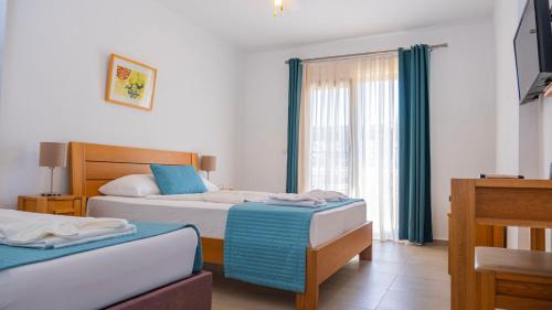a hotel room with two beds and a window at Otel Kefalos in Gokceada Town