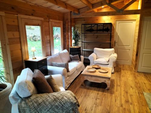 a living room with couches and a table at CHALET de la CHEVANNE in Laissey