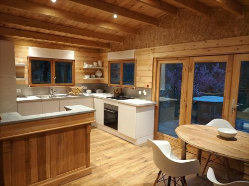 a kitchen with a table and a dining room at CHALET de la CHEVANNE in Laissey