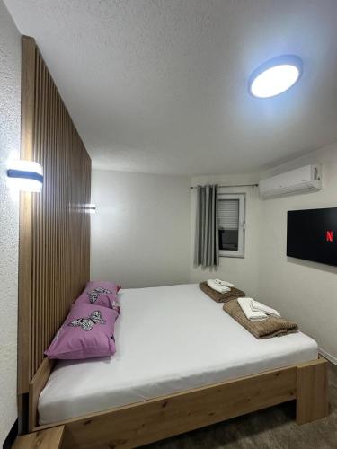 a bedroom with a large bed with purple pillows at Apartments Aventra in Visoko