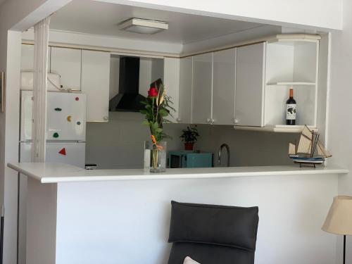 a kitchen with white cabinets and a white refrigerator at Pals apartament centric in Pals