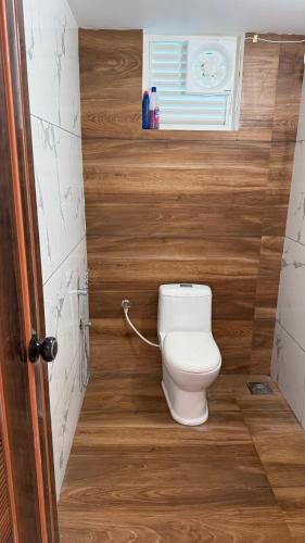 a bathroom with a white toilet in a room at Mayooram Back water Pool Villa in Kollam