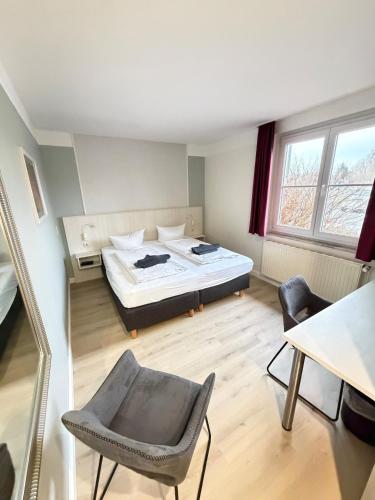a bedroom with a bed and a table and chairs at Hotel Brinckmansdorf in Rostock
