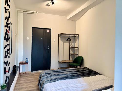 a bedroom with a bed and a green chair at E - Central Room Two in Skopje