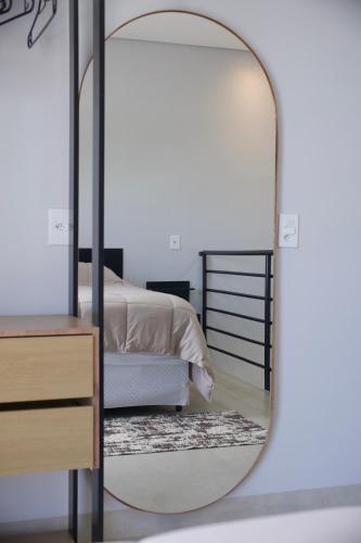 a mirror in a bedroom with a bed at Flat2 Aconchegante com Cozinha Completa in Sinop