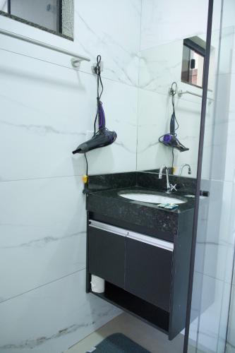 a bathroom with a sink and a mirror at Flat2 Aconchegante com Cozinha Completa in Sinop