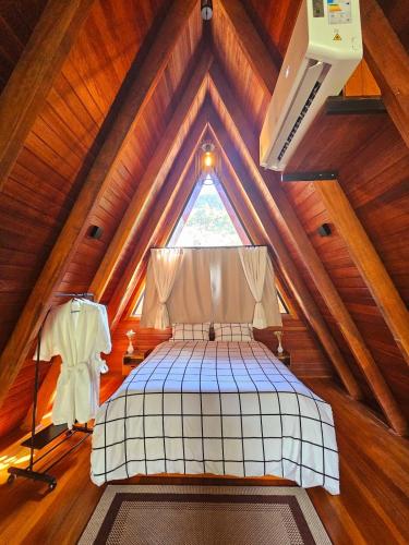a room with a bed in a wooden attic at Recanto do Guará Cabana in Capitólio