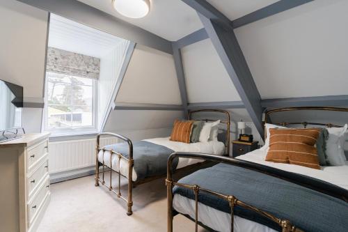 a bedroom with two bunk beds and a window at Port Gaverne Hotel in Port Isaac